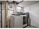 Laundry room featuring a modern washer and dryer setup, utility sink, and ample storage at 2276 S Dover Way, Lakewood, CO 80227