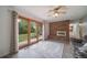 Bright living room with brick fireplace, ceiling fan, wood floors, and glass doors to the backyard at 2276 S Dover Way, Lakewood, CO 80227