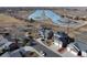 Aerial view showcasing the house with solar panels, proximity to neighborhood, and a body of water at 5895 E Conservation Dr, Frederick, CO 80504