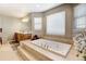 Bright bathroom featuring a large soaking tub on a raised platform with decorative tile at 5895 E Conservation Dr, Frederick, CO 80504