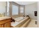 Spacious bathroom featuring a large soaking tub on a raised platform with decorative tile at 5895 E Conservation Dr, Frederick, CO 80504