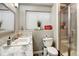 Bright bathroom featuring a sink, toilet, and glass-enclosed shower with decorative tile accents at 5895 E Conservation Dr, Frederick, CO 80504