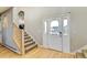 Inviting entryway featuring a wood staircase, front door with arched window, and light hardwood flooring at 5895 E Conservation Dr, Frederick, CO 80504