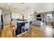 Spacious kitchen open to the living room with a large island, white cabinets, and hardwood floors at 5895 E Conservation Dr, Frederick, CO 80504