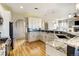 Modern kitchen with white cabinetry, granite countertops, stainless steel appliances and hardwood floors at 5895 E Conservation Dr, Frederick, CO 80504