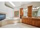 Large primary bathroom featuring a skylight, built in tub, and double sink vanity with wood cabinets at 16442 Rocky Point Ln, Morrison, CO 80465