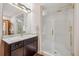 Modern bathroom features sleek fixtures, a granite vanity, a glass shower door, and updated lighting at 16442 Rocky Point Ln, Morrison, CO 80465
