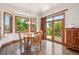 Cozy dining area with hardwood floors, large windows, and access to a deck overlooking the beautiful outdoors at 16442 Rocky Point Ln, Morrison, CO 80465