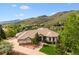 Charming single-story home with a well-manicured lawn set against a backdrop of rolling hills at 16442 Rocky Point Ln, Morrison, CO 80465