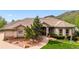 Charming front exterior showcasing a well-manicured lawn, mature landscaping, and a tiled roof at 16442 Rocky Point Ln, Morrison, CO 80465