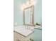 Stylish bathroom featuring a light blue accent wall, decorative mirror, and modern fixtures at 958 S Columbine St, Denver, CO 80209