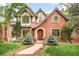 Charming brick home with Tudor-style accents, arched entry, and professionally landscaped front yard at 958 S Columbine St, Denver, CO 80209