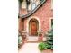 Inviting front entrance featuring an arched stone entryway, wooden door, and decorative iron gate at 958 S Columbine St, Denver, CO 80209