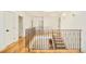 Upstairs hallway displaying iron railing, hardwood floors and doors leading to other rooms at 958 S Columbine St, Denver, CO 80209