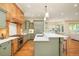 Spacious kitchen with hardwood floors, an island, light green cabinets, stainless steel appliances, and modern lighting at 958 S Columbine St, Denver, CO 80209