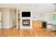 Open-concept living room with a fireplace, custom shelves, wet bar, and hardwood floors at 958 S Columbine St, Denver, CO 80209