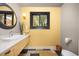 Bathroom with a black framed window, yellow walls, patterned tile floor, and modern sink and fixtures at 1579 W Costilla Pl, Littleton, CO 80120