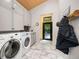 Modern laundry room with stainless steel appliances, wood ceiling and stylish cabinets at 1579 W Costilla Pl, Littleton, CO 80120