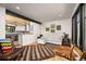 Bright living room featuring hardwood floors, black-trimmed windows and an open layout connecting to the kitchen area at 1579 W Costilla Pl, Littleton, CO 80120