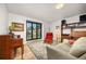 Comfortable living room featuring a piano, a large window, and wood shelving at 1579 W Costilla Pl, Littleton, CO 80120