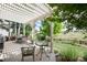 Charming covered back patio features a pergola, multiple seating areas, and green backyard at 3027 Walnut Grove St, Erie, CO 80516