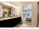 Bright bathroom featuring double sinks, granite counters, and a glass enclosed shower at 3027 Walnut Grove St, Erie, CO 80516