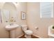 Charming powder room with pedestal sink, framed art, and natural light from window at 3027 Walnut Grove St, Erie, CO 80516