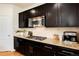 A close up shot of the kitchen with dark cabinets and granite countertops at 3027 Walnut Grove St, Erie, CO 80516