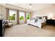 Bright main bedroom boasts three large windows, ceiling fan, and neutral carpet at 3027 Walnut Grove St, Erie, CO 80516