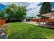 Expansive backyard with lush green lawn, patio dining area, and a detached garage at 1650 S Holly St, Denver, CO 80222
