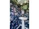 Stylish bathroom with whimsical wallpaper, pedestal sink, and decorative fixtures at 1650 S Holly St, Denver, CO 80222