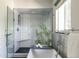Beautiful bathroom featuring a modern soaking tub, glass shower, and stylish tile at 1650 S Holly St, Denver, CO 80222