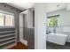 Bright bathroom featuring a soaking tub, subway tile, a custom closet, and hardwood floors at 1650 S Holly St, Denver, CO 80222