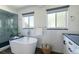 Bright bathroom features a stand-alone soaking tub and a separate glass shower at 1650 S Holly St, Denver, CO 80222
