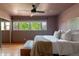 Bright bedroom featuring large windows, a ceiling fan, and a comfortable king bed at 1650 S Holly St, Denver, CO 80222