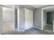 Neutral bedroom features grey walls and carpet, with a sliding closet door and access to other rooms at 1650 S Holly St, Denver, CO 80222