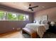 Cozy bedroom featuring a ceiling fan, a large window view, and a comfortable king bed at 1650 S Holly St, Denver, CO 80222