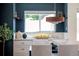 Dining area features a modern light fixture and a dark blue accent wall at 1650 S Holly St, Denver, CO 80222