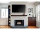Close-up of a modern, white-brick fireplace with wood mantel and hearth at 1650 S Holly St, Denver, CO 80222