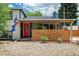 Charming home featuring a red door, wood slat accent wall, and Colorado flag at 1650 S Holly St, Denver, CO 80222