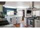 Open kitchen and dining area with stainless steel appliances and hardwood floors at 1650 S Holly St, Denver, CO 80222