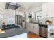 Well-lit kitchen featuring stainless steel appliances, white cabinets, and gray countertops at 1650 S Holly St, Denver, CO 80222