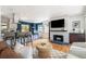 Open-concept living room with hardwood floors, white brick fireplace, and bar seating at 1650 S Holly St, Denver, CO 80222