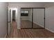 Bedroom with sliding mirror door closet and wood-look flooring at 7255 E Quincy Ave # 205, Denver, CO 80237