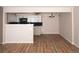 An open living room with new floors flows into the kitchen, with dark backsplash at 7255 E Quincy Ave # 205, Denver, CO 80237