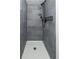 Modern shower with gray tile surround, rainfall shower head and sleek fixtures at 7255 E Quincy Ave # 205, Denver, CO 80237