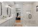 Elegant bathroom featuring double vanities, a glass-enclosed shower, and views into the primary bedroom at 354 Milwaukee St, Denver, CO 80206