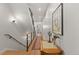 Bright hallway with a wooden staircase, modern railing, and a decorative table with a painting at 354 Milwaukee St, Denver, CO 80206