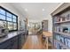 Bright hallway featuring a bookshelf and adjacent office space with a large window and wood floors at 354 Milwaukee St, Denver, CO 80206