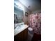 Bathroom with a single sink, vanity and a shower with a floral curtain at 9950 Sydney Ln, Highlands Ranch, CO 80130